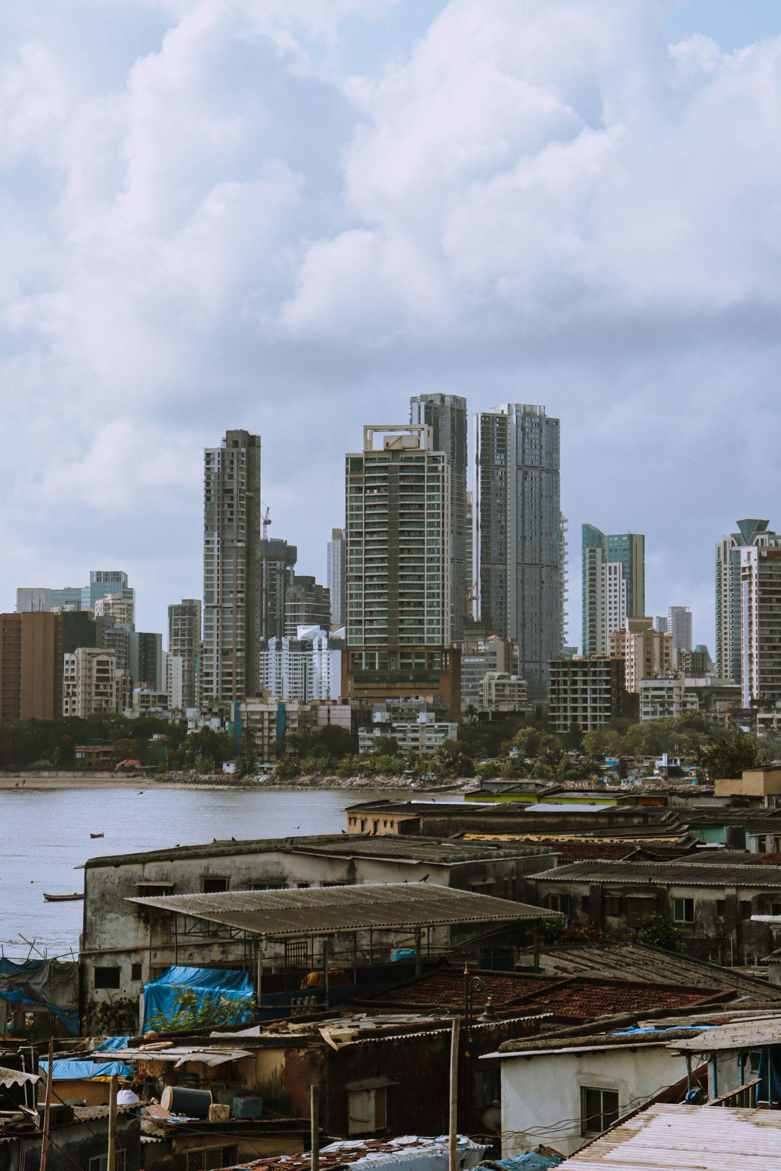 High-rise towers rising behind low-rise rooftops across the water.