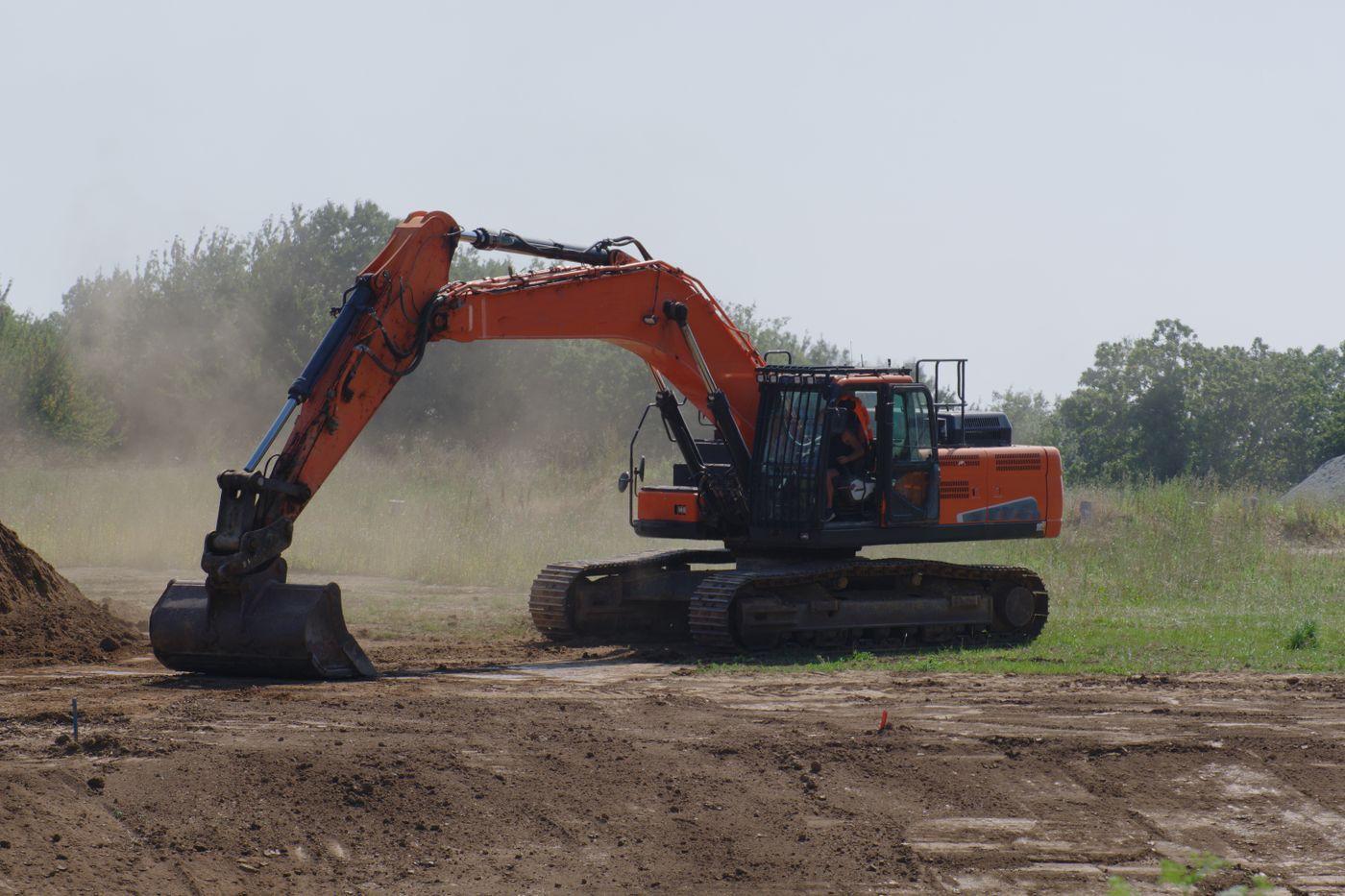 An excavator levelling ground on a cleared site.