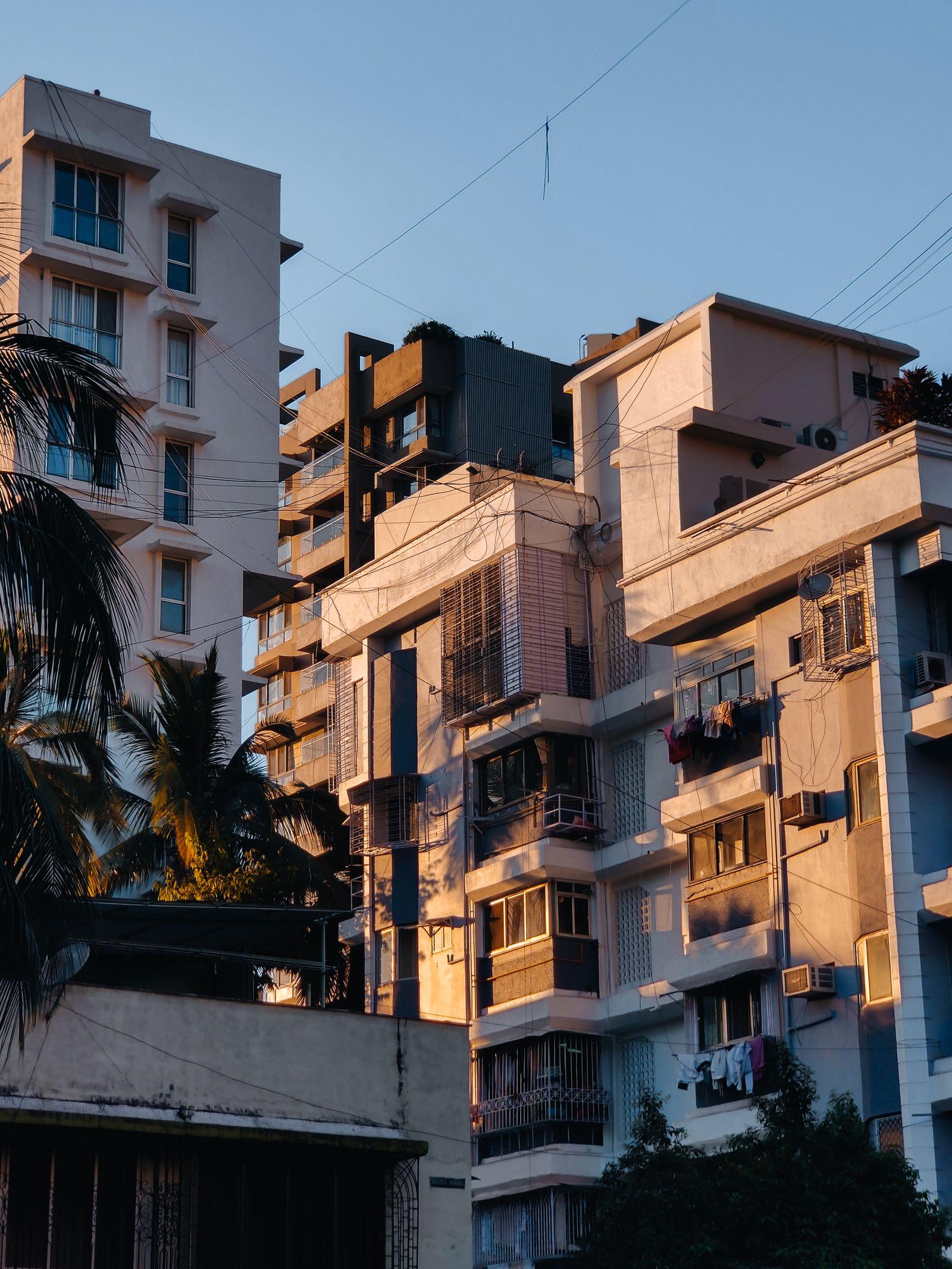 Mid-rise apartment blocks lit by evening sun.