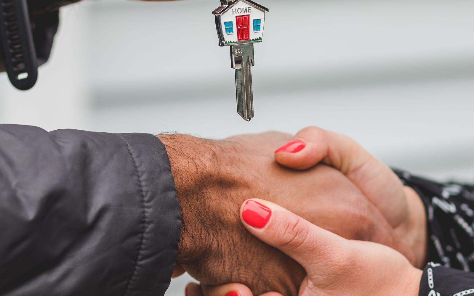 A handshake as a house key changes hands.